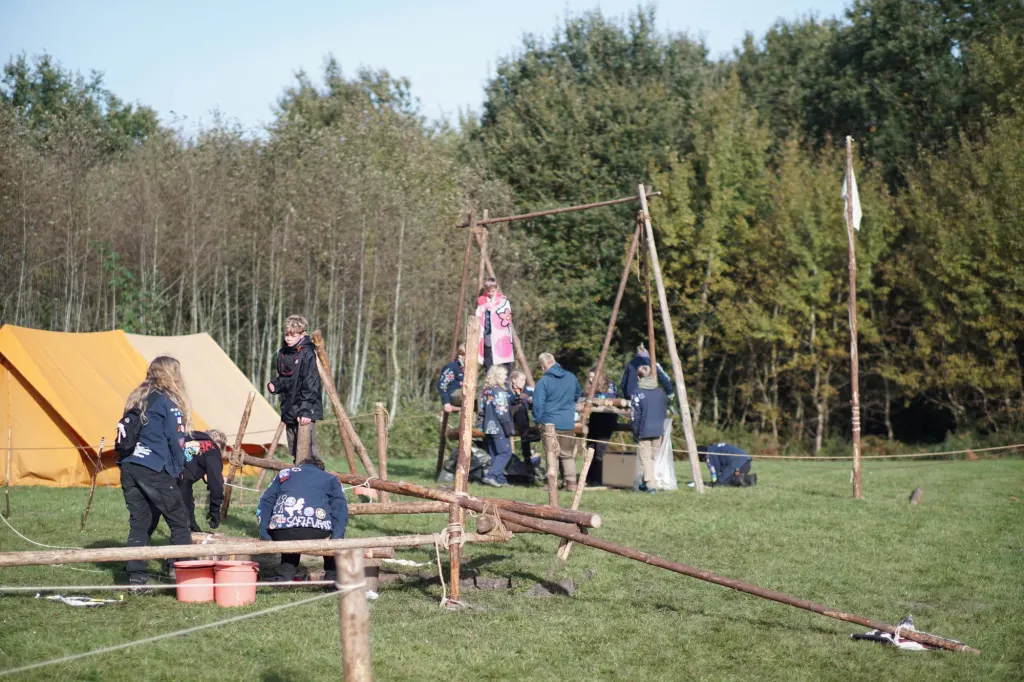 Telte og rafter på en græsmark i efterårslys
